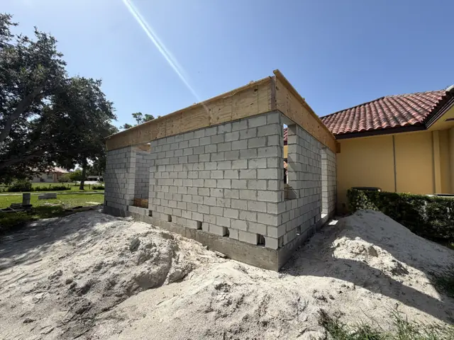 CMU walls rising beside the existing home — Palm Beach Gardens, FL